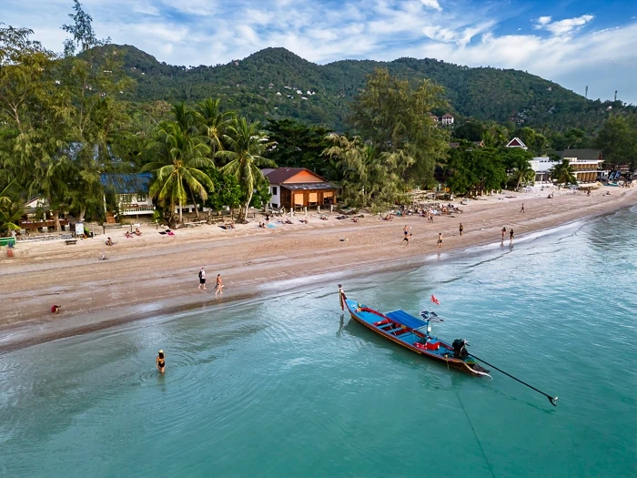 A longtail boat parked in the clear blue water of Sairee Beach, the biggest beach on Koh Tao