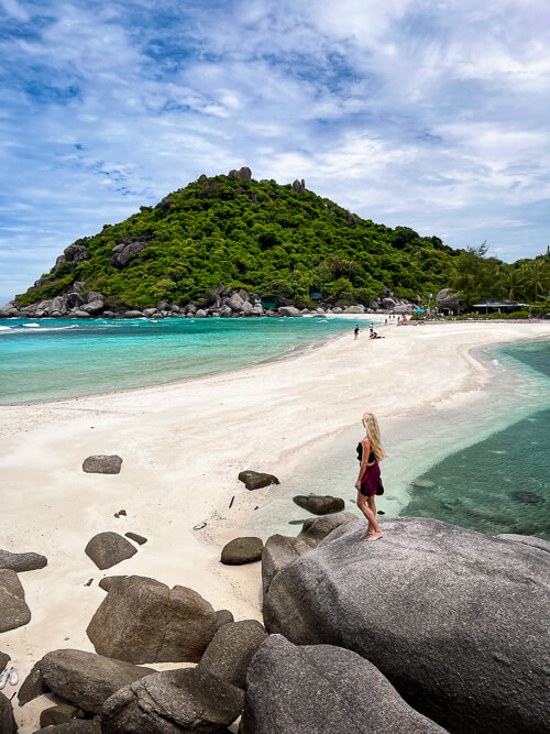 Me standing on a big rock next to a white sandbank surrounded by turquoise water at Koh Nang Yuan Island.