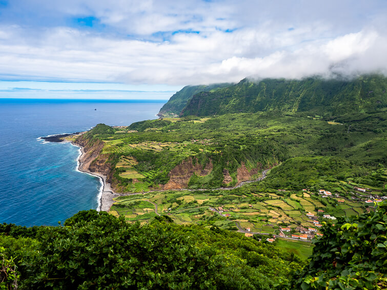 A panoramic view of the verdant green mountains, small villages and pastures on the west coast of Flores Island.
