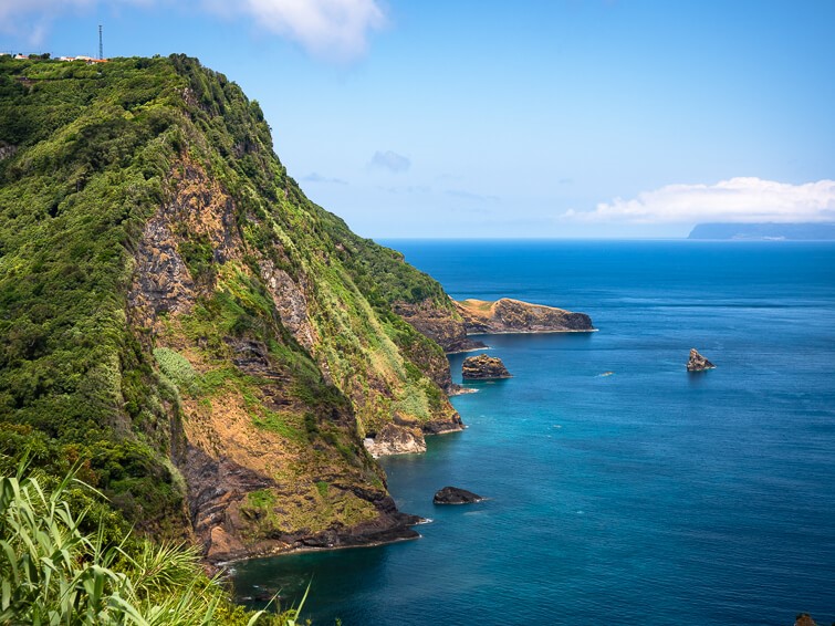 Steep cliffs rising out of the turquoise sea along the jagged east coast of Flores Island.