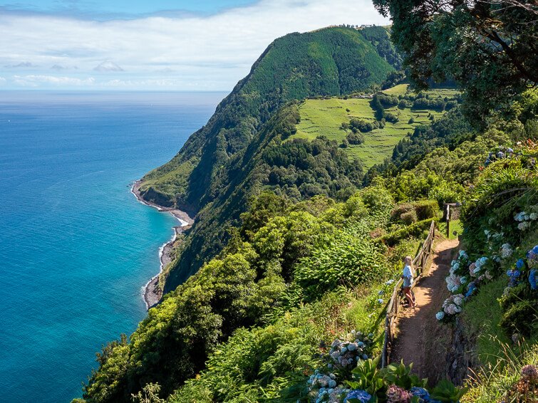 A view of the east coast of Sao Miguel with its turquoise ocean and steep cliffs covered with lush vegetation.