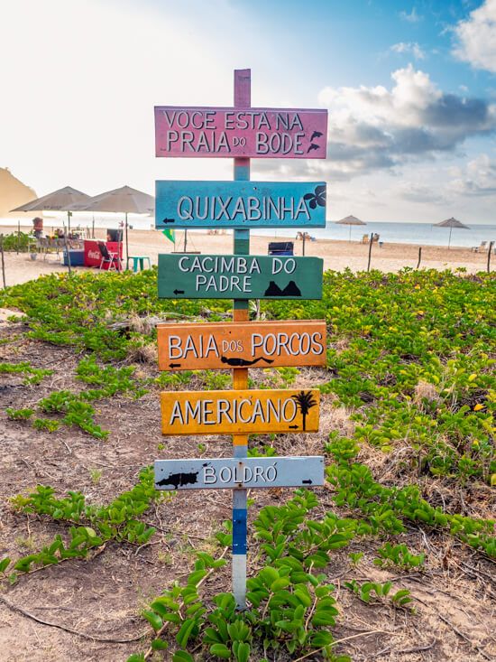 A sign post with several colorful signs at Bode Beach