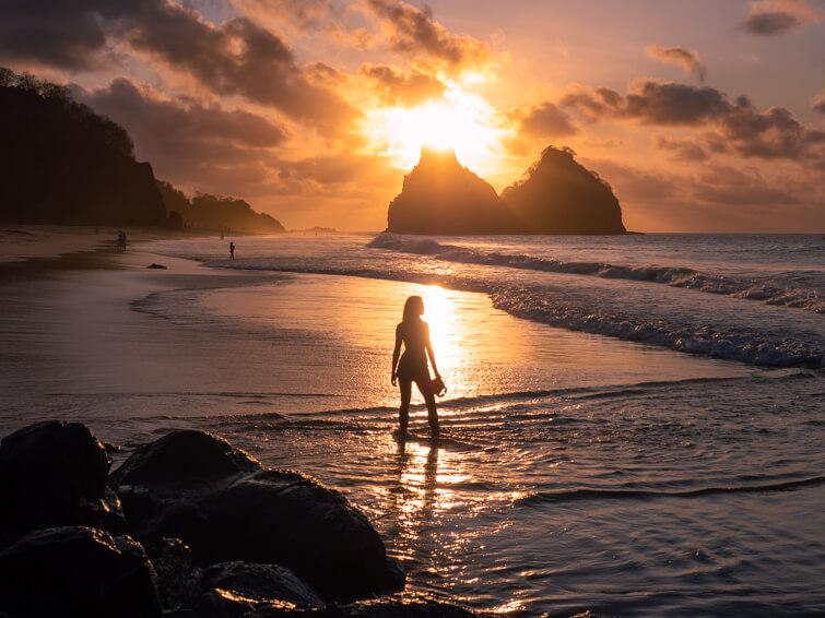Me standing in the water at Bode Beach with the Morro Dois Irmaos mountains in the background during sunset.