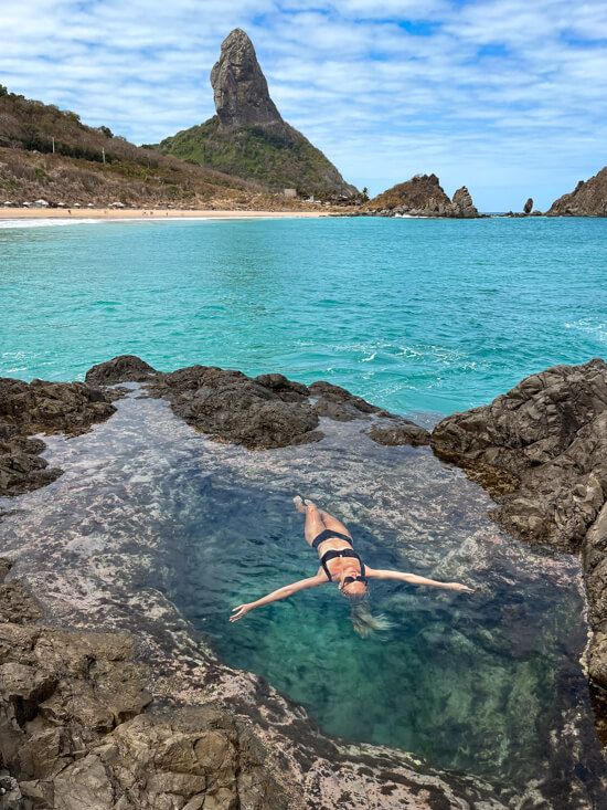 Me floating on my back in a small natural pool next to Praia do Cachorro, with Pico Mountan in the background.