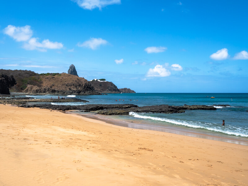The flat and sandy Praia do Porto beach with calm water next to the harbor of Fernando de Noronha.
