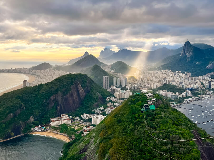 A panoramic view from the Sugarloaf Mountain over the city of Rio de Janeiro with its high-rise buildings and mountainous landscape.