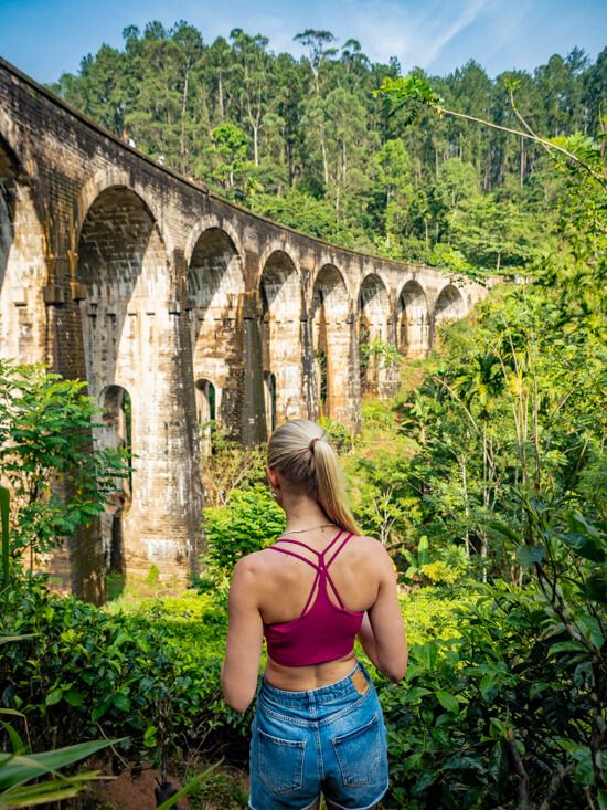 Me posing in front of the Nine Arch Bridge, one of the best places to visit in Ella. 