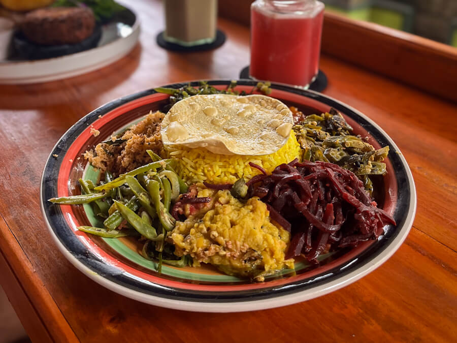 A plate full of rice and various Sri Lankan curries consisting of different vegetables.