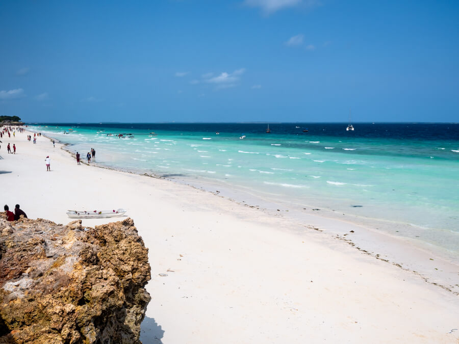 A long stretch of white sand and turquoise sea with gentle waves at Nungwi, Zanzibar.