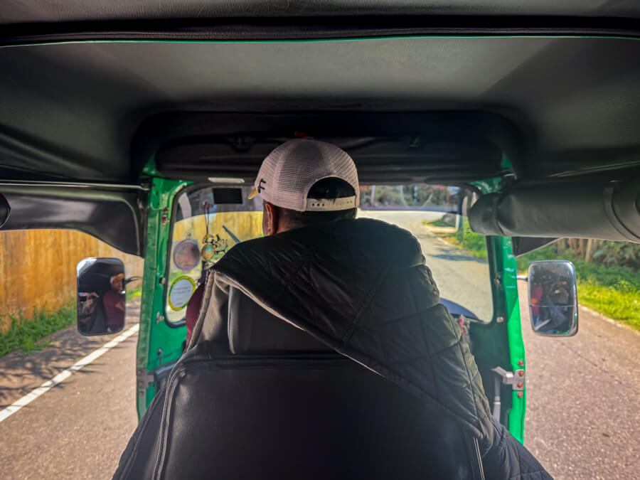 A man driving a tuk-tuk on the streets of Sri Lanka.