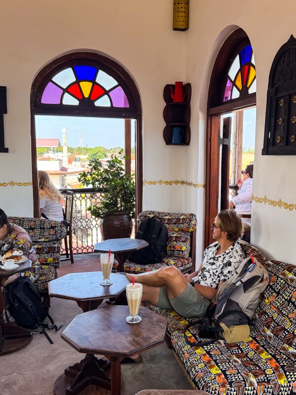 A rooftop cafe with large windows with stained glass.