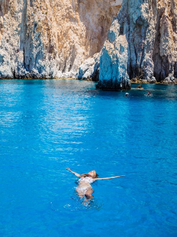 Me floating on my back in the blue water at Polyaigos Island on our Milos boat tour.