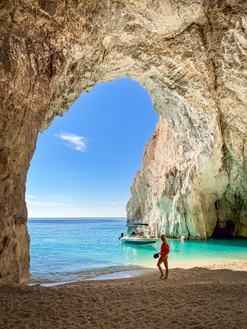 Me standing at the mouth of a huge sea cave in the turquoise waters of Zakynthos, Greece.